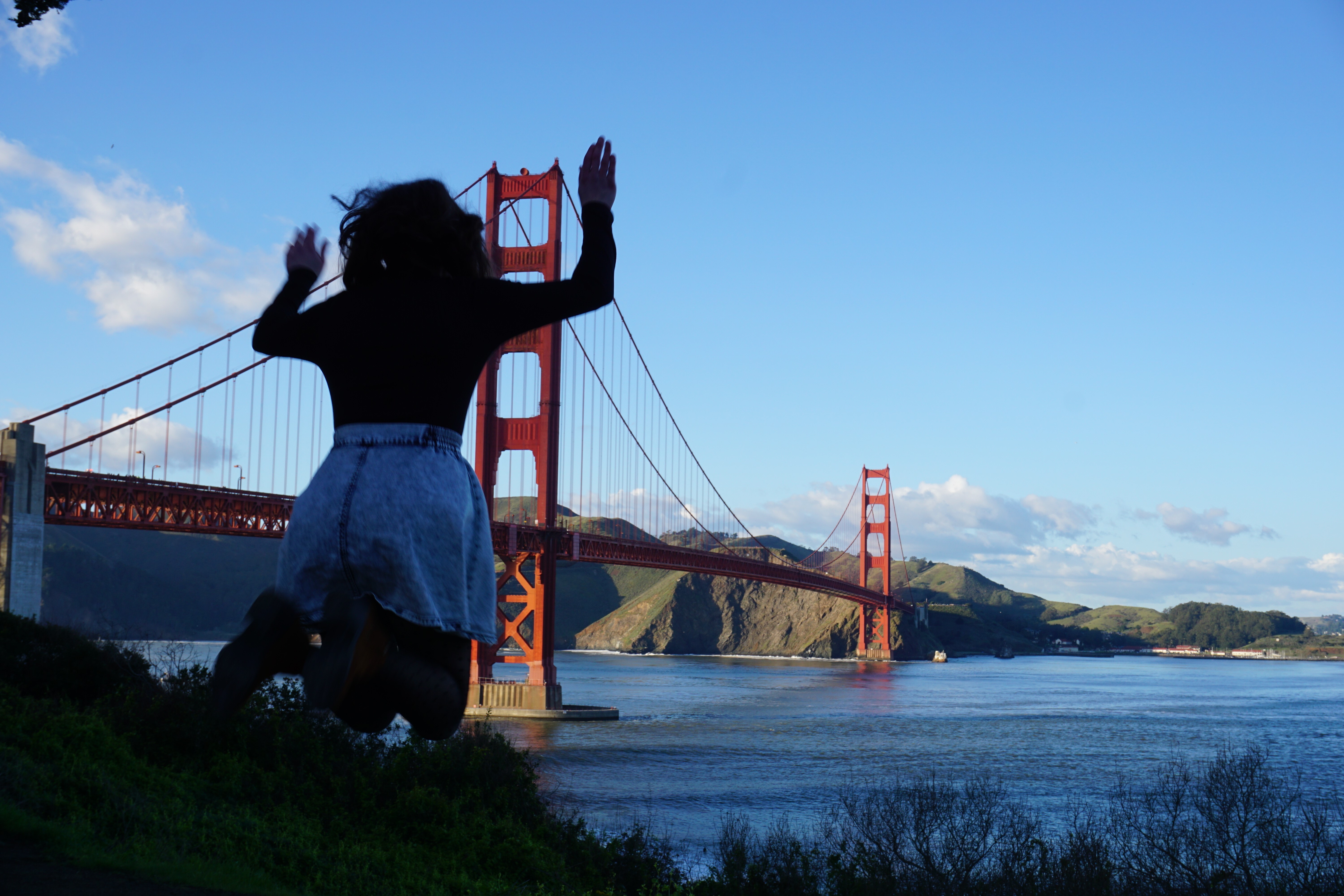 Maria jumping in front on the Golden Gate Bridge.