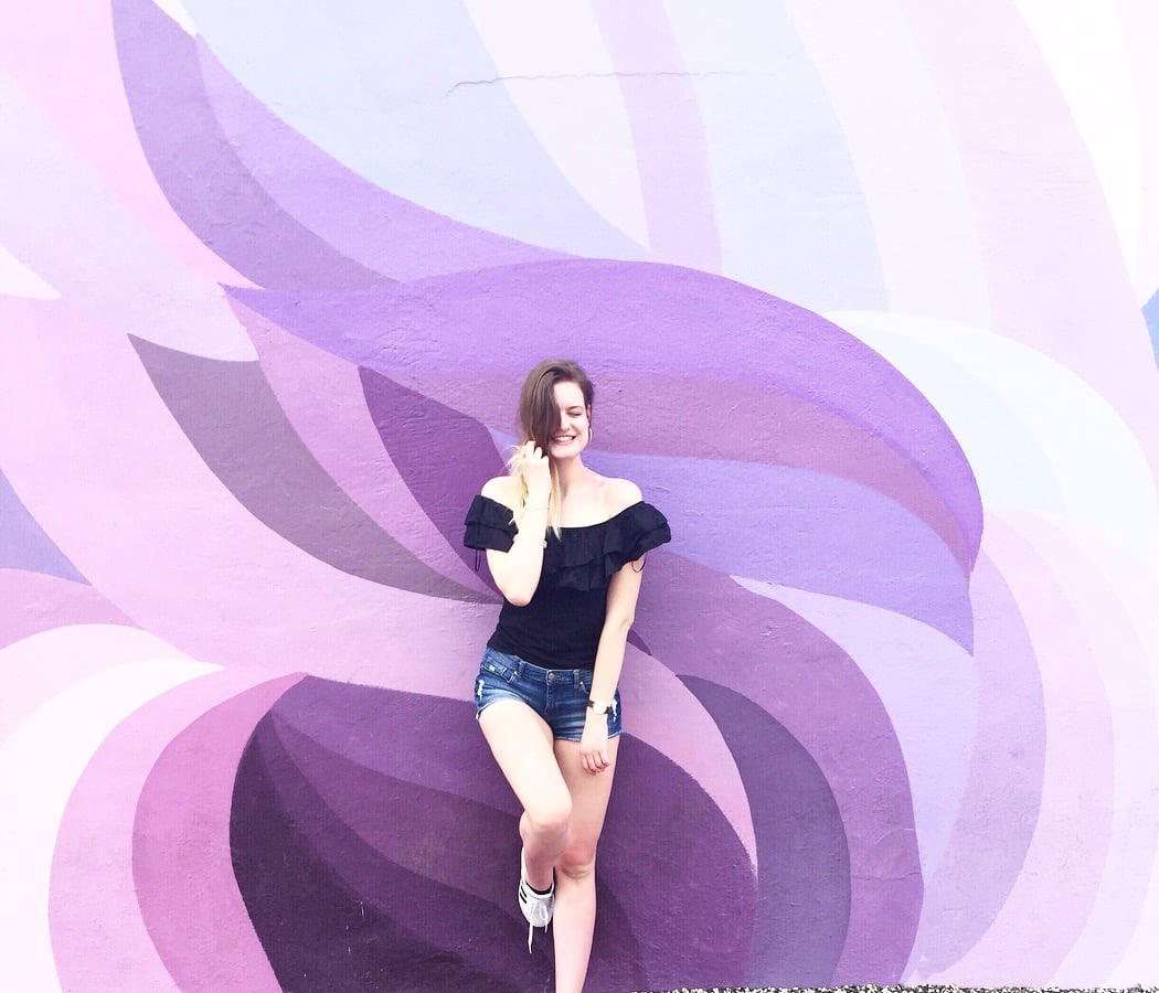 Vanessa posing in front of an art wall at Wynwood Art district