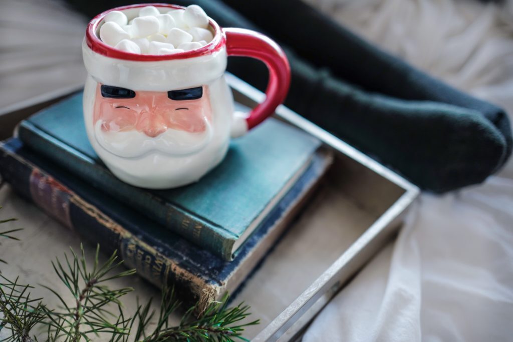 Pile of books with a Santa mug on top